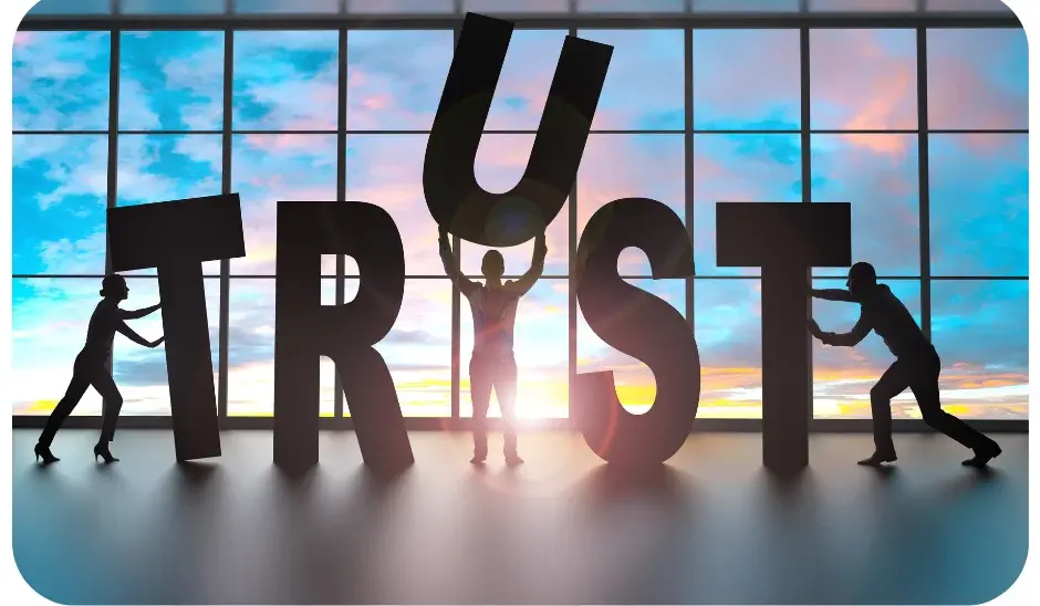 Silhouettes of people holding large letters spelling TRUST, symbolising business reliability.